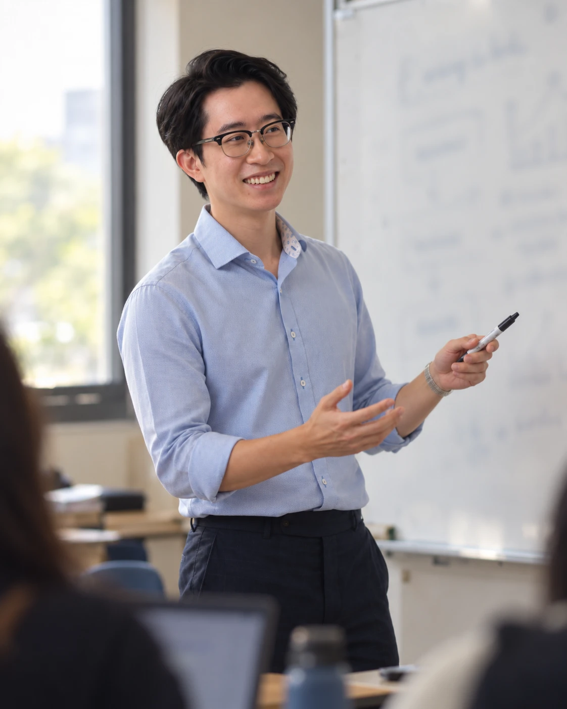 Mr Cameron Kheng teaching at the whiteboard, marker in hand